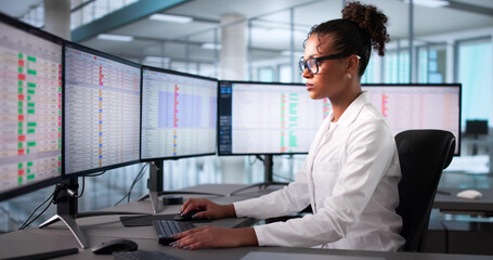 African-American Nurse Coding Medical Invoices With Hospital Technology