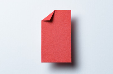 Red blank paper note cardboard with folded corner dog-ear earmark, drop shadow and copy space for text on white background
