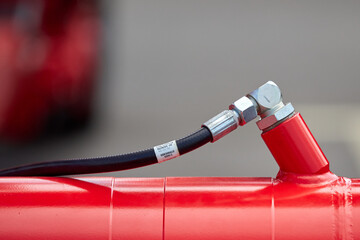 Close-up of two hydraulic hose fittings attached to a red industrial machine