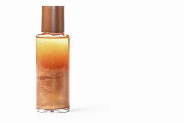A transparent bottle of liquid body cosmetic that contains gold dust and is shiny.