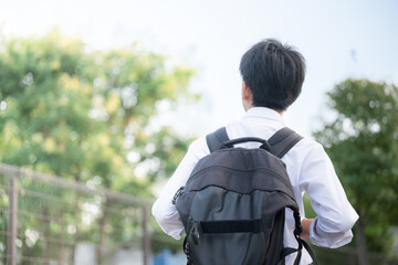 通学をする中学生や高校生のリュックの後ろ姿顔無し　学校生活を頑張る歩く、未来や希望のイメージ