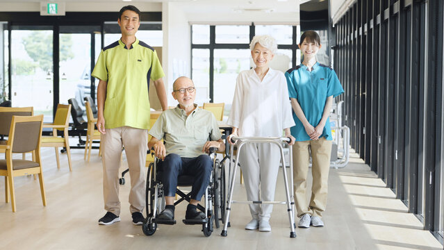 高齢者の歩行サポートをするアジア人介護士
