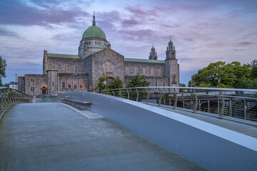 Galway cathedral of Our Lady Assumed into Heaven and St Nicholas in the morning before the sunrise seen across the bridge on a summer day, Ireland