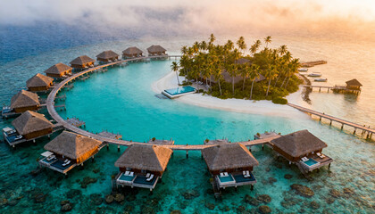 Aerial drone view of a luxury tropical island resort in the Maldives with overwater bungalows. Paradise vacation, summer holiday, honeymoon travel, and exotic escape concept.