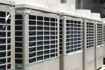 Close-up of multiple outdoor air conditioning units (HVAC system) installed in a row. Used for cooling large buildings, factories, and commercial facilities