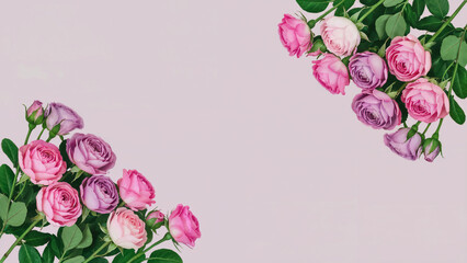 Arrangement of pink and purple roses with green leaves on a light pink background in the upper corners