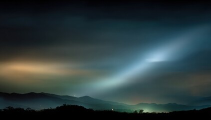 Fototapeta premium Mountain silhouettes bathed in ethereal, pale light at night, creating a tranquil and mysterious landscape.