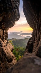 Sunrise view through rock formation; misty valley below