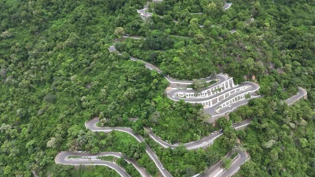 Drone shot of the serpentine ghat road at Kolli Hills, one of India's most challenging drives. The road is carved into the tropical, thick Eastern Ghats vibrant tropical forests.