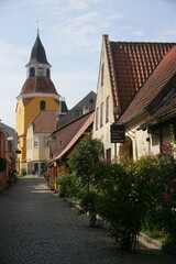 Vicolo storico con torre dell'orologio e case colorate a Faaborg, Danimarca