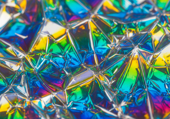 Abstract holographic texture with vibrant rainbow colors and geometric patterns, creating a futuristic and dazzling visual effect