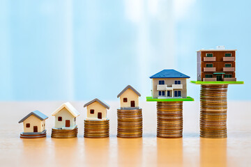 Miniature Houses Stacked on Coins Representing Real Estate Growth housing property isolated on a transparent background