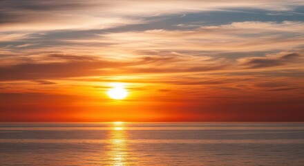 Obraz premium Vibrant sunset over calm ocean waters reflecting fiery orange and golden hues