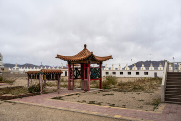 A Buddhist temple against the backdrop of the steppe and mountains on an autumn day in Mongolia.