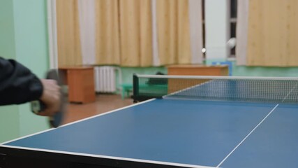 Close up hand view of players hitting tennis ball across table during indoor match, paddle and ball captured mid action, showcasing fast paced dynamics of competitive table tennis play - Powered by Adobe