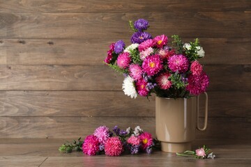 Beautiful flowers in vase on table against wooden background, space for text