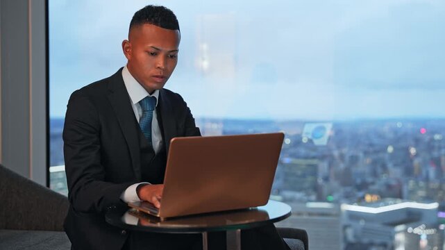 ビジネス、ビジネスマン、ノートパソコン、男性、タイピング、オフィス、ビジネスパーソン、PC、DX、仕事、作業、スーツ、夜、高層ビル、窓、風景、景色、都市、社会、経営者、インターネット、オンライン、web、検索、経営、人材、外国人、黒人、グローバル、働く、事務、企業、会社員、デジタル、データ、クラウド、AI、ERP、システム、開発、エンジニア、プロフェッショナル、通信、メール、ネットワーク、wi-f