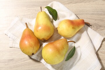 Many fresh pears and leaves on wooden table, flat lay