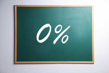 Zero percent commission. Chalkboard with 0% hanging on white wall