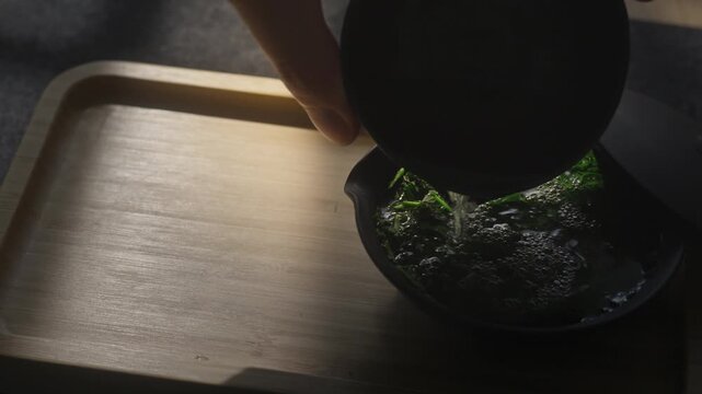 Pouring green leaves of Japanese gyokuro tea in shiboridashi is a ritual associated with longevity and good health
