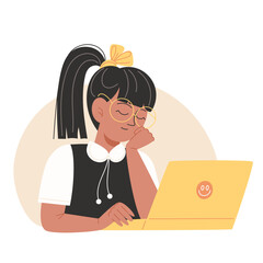 A girl wearing glasses and a bow sits at a yellow laptop