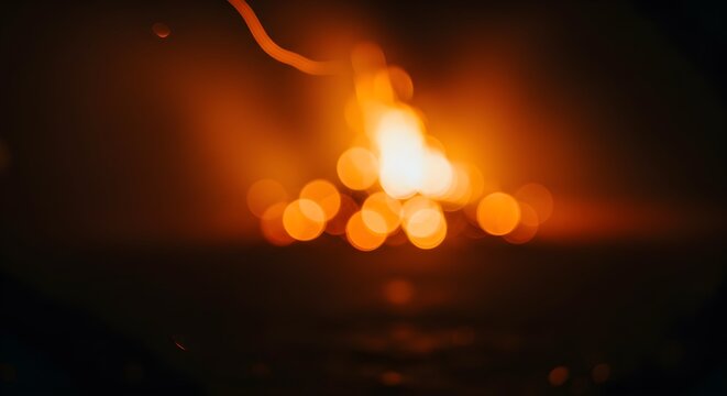 Blazing campfire with vibrant orange and yellow bokeh effect in darkness