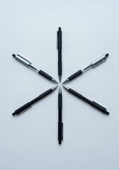 Star-shaped arrangement of sleek pens on a pristine white background