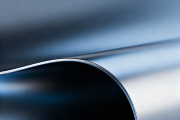 Close-up of a curved metallic surface with smooth, reflective finish and soft lighting