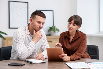 Consultant working with client at table in office. Business meeting