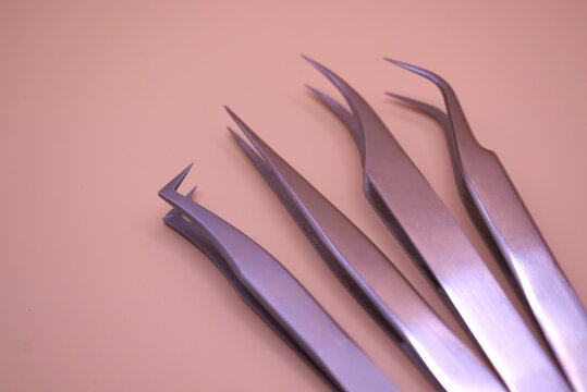 eyelash extension tweezers on a plain background. - Powered by Adobe