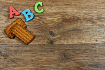 ABC Letters and Biscuit on Wooden Desk Create Warm Educational Stock Photo