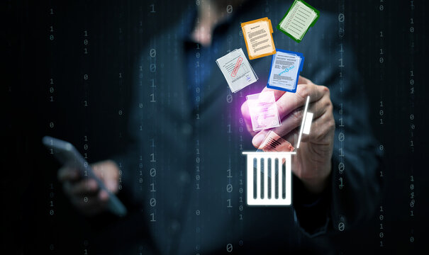 Businessman using smartphone and hologram interface to delete digital documents into recycle bin, symbolizing secure file management, data cleanup, and cybersecurity concept.