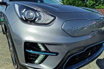 Modern electric car parked under the blue sky showcasing its sleek design and innovative features in a lively urban environment
