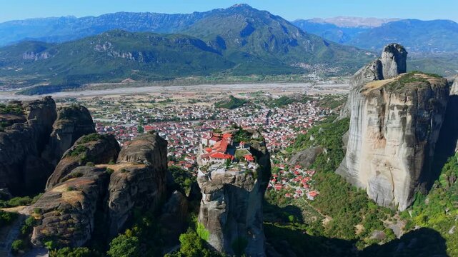 Aerial View of the Great Meteoron Monastery atop Towering Rock in Meteora and town houses of Kalambaka, Greece