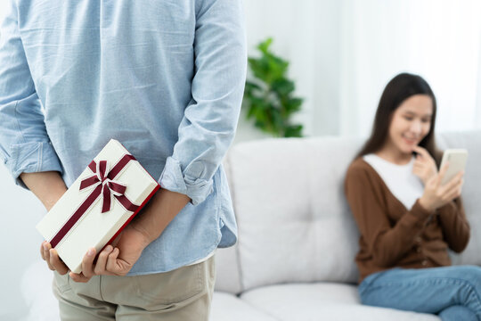 Happy husband seek and hide gift box for surprise wife. cute girl excited  gift box. birthday, Celebration, xmas, New year Festival, thank, Celebrate, Valentine's Day, Anniversary married