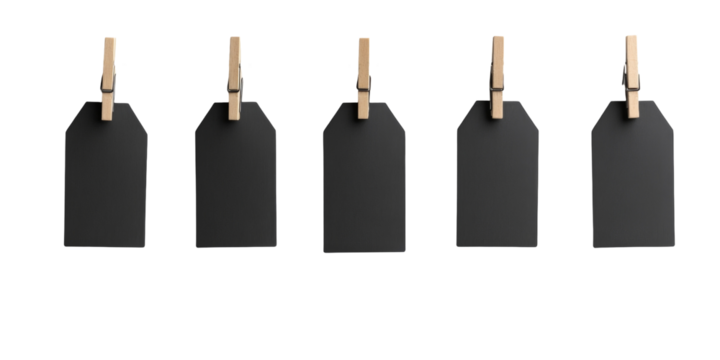 Five blank black tags hanging on wooden clips in a row against black background