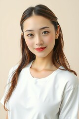 Fototapeta premium A slender faced Japanese woman with voluminous, long hair poses in a simple white t-shirt.