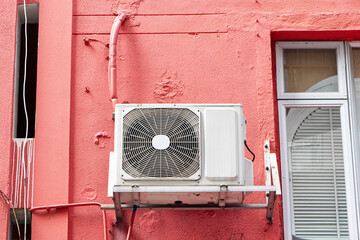 Structure of old air conditioner compressor source heat pumps and electrical circuit board on old wall pastel colors on of building. Cooling pump technology for home or office industrial plant.