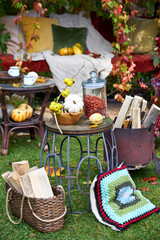 Cozy autumn still life in a garden with rustic table, pumpkins, quinces, glass jar, and warm seasonal decor. Outdoor fall atmosphere with natural colors, homely comfort, and countryside charm, perfect