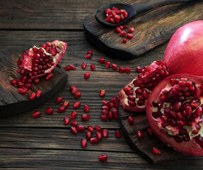 A beautiful ripe pomegranate on a dark wooden table. A variety of conceptual photos of pomegranates. Variable ideas for creating a look.
