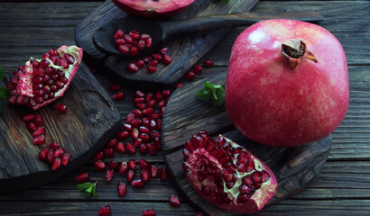 A beautiful ripe pomegranate on a dark wooden table. A variety of conceptual photos of pomegranates. Variable ideas for creating a look.