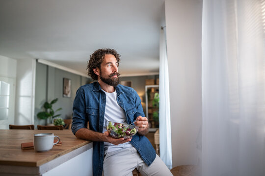 Man eating healthy salad enjoying thoughtful moment