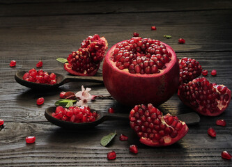 A beautiful ripe pomegranate on a dark wooden table. A variety of conceptual photos of pomegranates. Variable ideas for creating a look.