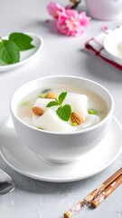Creamy soup with white cubes and almonds