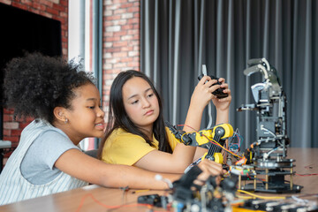 Diverse Young Girls Collaborating on a Robotics Engineering Project, Students Focusing on Building and Programming a Robotic Arm in STEM Class, Children Learning Hands-on Technology and Innovation