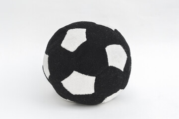 Soccer ball made of soft black and white fabric on a white background