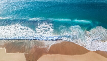 beautiful aerial view of gentle ocean waves washing over sandy beach with vibrant blue water and soft foam patterns captured in high detail