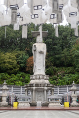 Mireuk Daebul statue of the bodhisattva Maitreya at Bongeunsa Temple, a Buddhist temple in Seoul. With background of autumn leaves. It is the tallest stone statue in Korea.