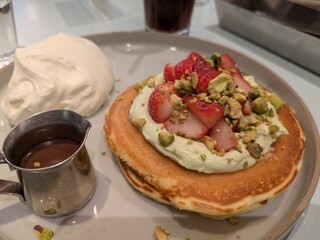 クリームの添えられたいちごとピスタチオのパンケーキ