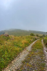 Fog in the mountains during cloudy weather in Cantabria, Spain, creating a dramatic and mysterious natural landscape.
